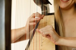 Naked teen harpist creates music