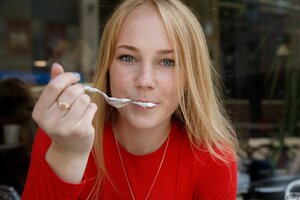 Beautiful blonde teen loves posing outdoors and eating ice-cream