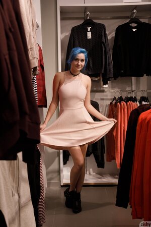 Hot cheery teen with blue-hair enjoys shopping and trying on clothes